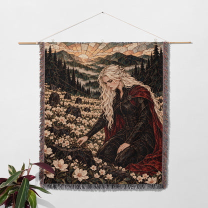 Flowers for the Fallen Woven Throw Blanket hanging on a wall with a plant