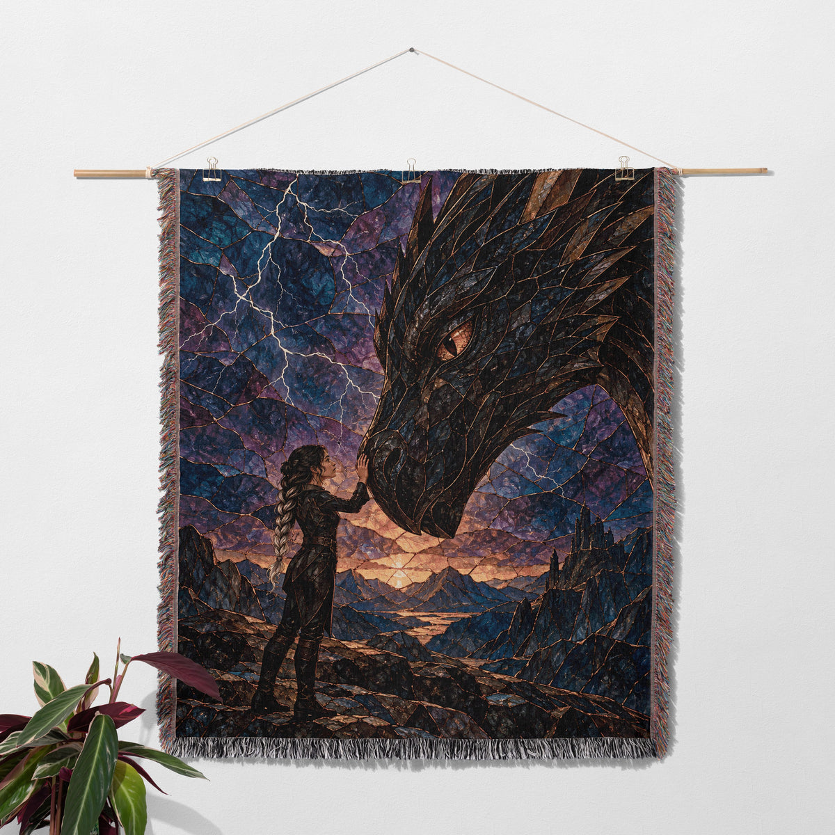 Dragon Rider Woven Throw Blanket hanging on a wall with a plant