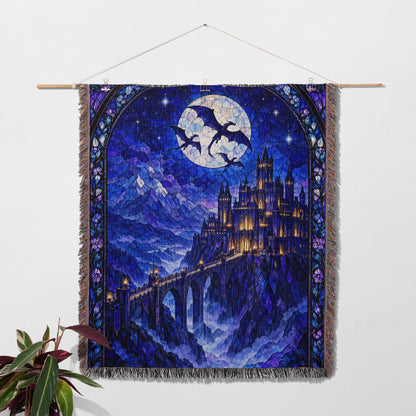 Basgiath by Night Stained Glass Woven Throw Blanket hanging on a wall with a plant
