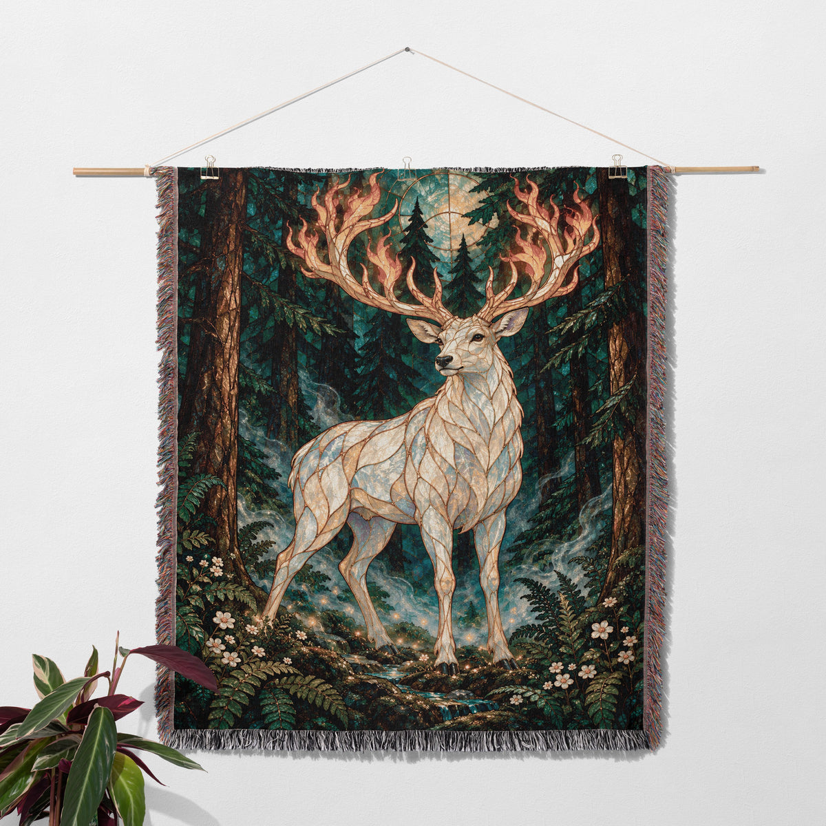 Terrasen Stag Woven Throw Blanket hanging on a wall with a plant