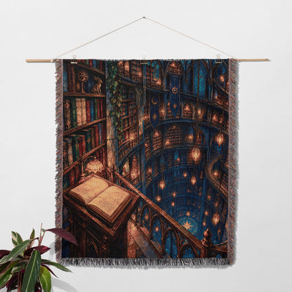 Midnight House of Wind Woven Throw Blanket hanging on a wall with a plant