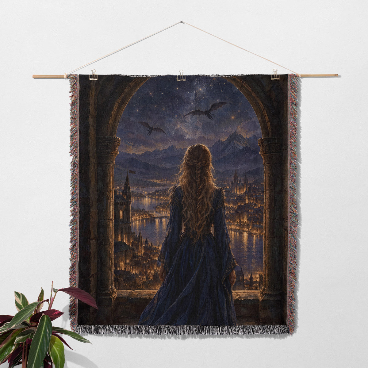 Feyre over Velaris Woven Throw Blanket hanging on a wall with a plant