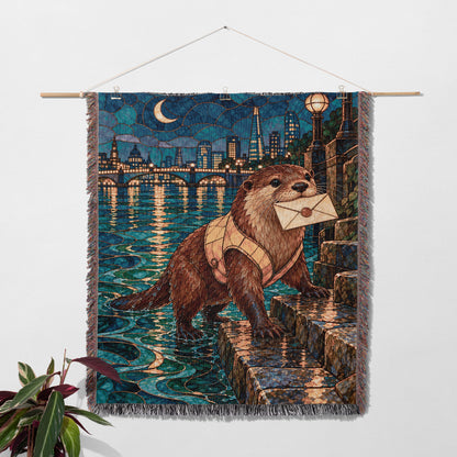 Otter Woven Throw Blanket hanging on a wall with a plant