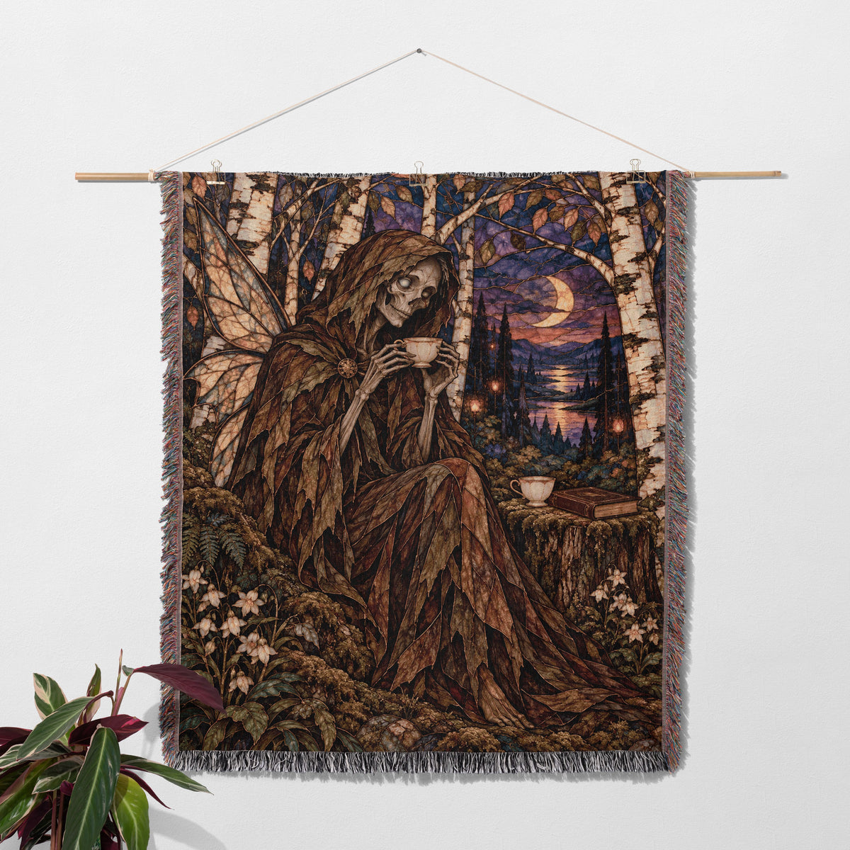 Suriel Tea Woven Throw Blanket hanging on a wall with a plant
