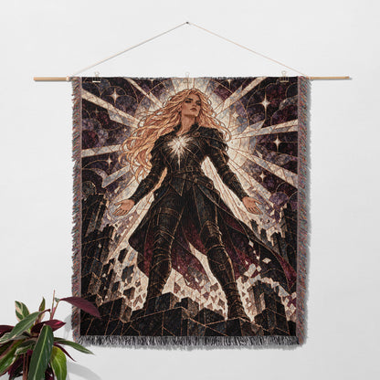 Asterin's Yielding Woven Throw Blanket hanging on a wall with a plant