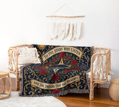 To The Stars Who Listen Rose Crest Woven Throw Blanket on a rattan chair