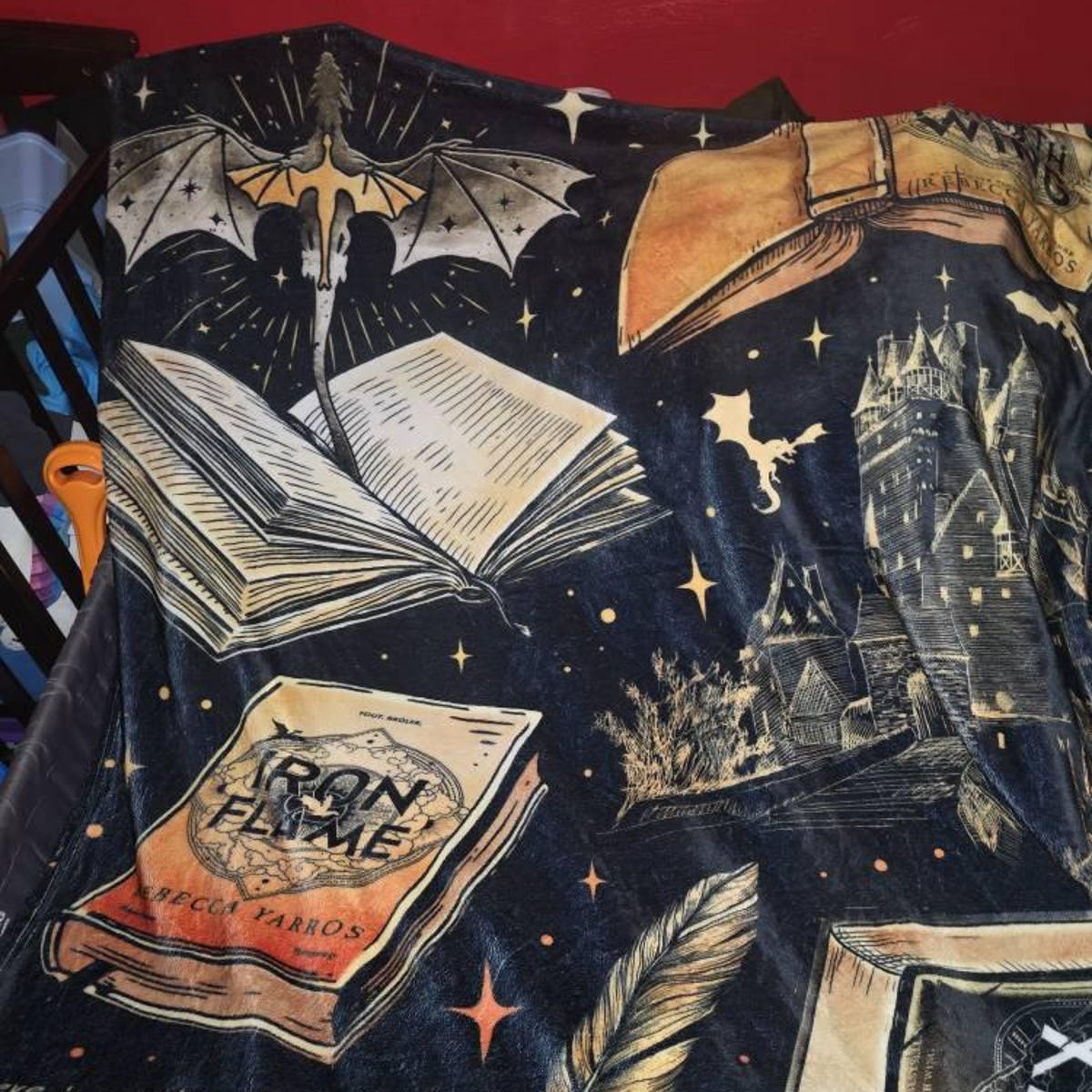 Customer photo: the Fourth Wing books and dragon velveteen plush blanket spread over a bed.